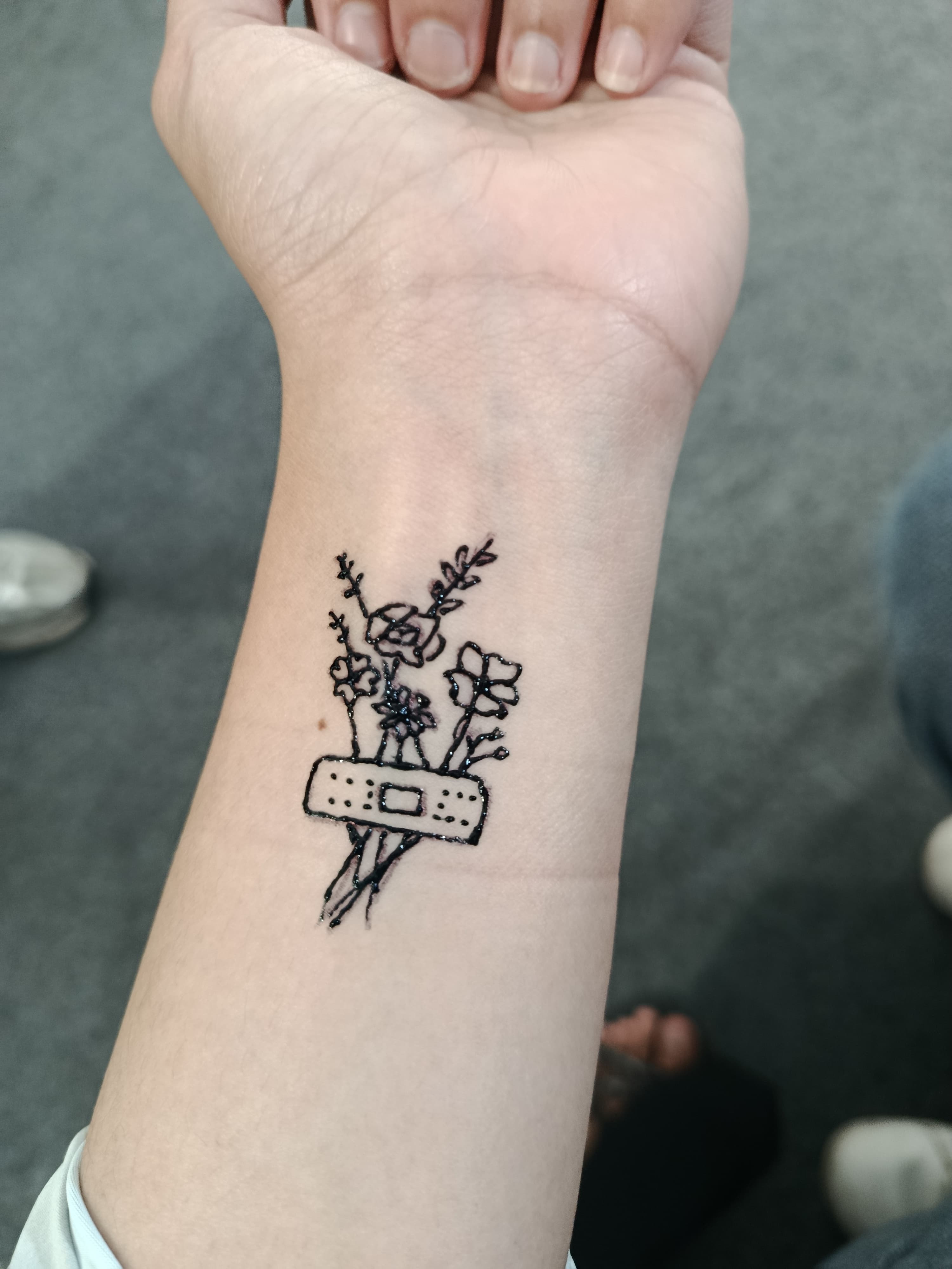 Fine-line bouquet tattoo on an inner wrist