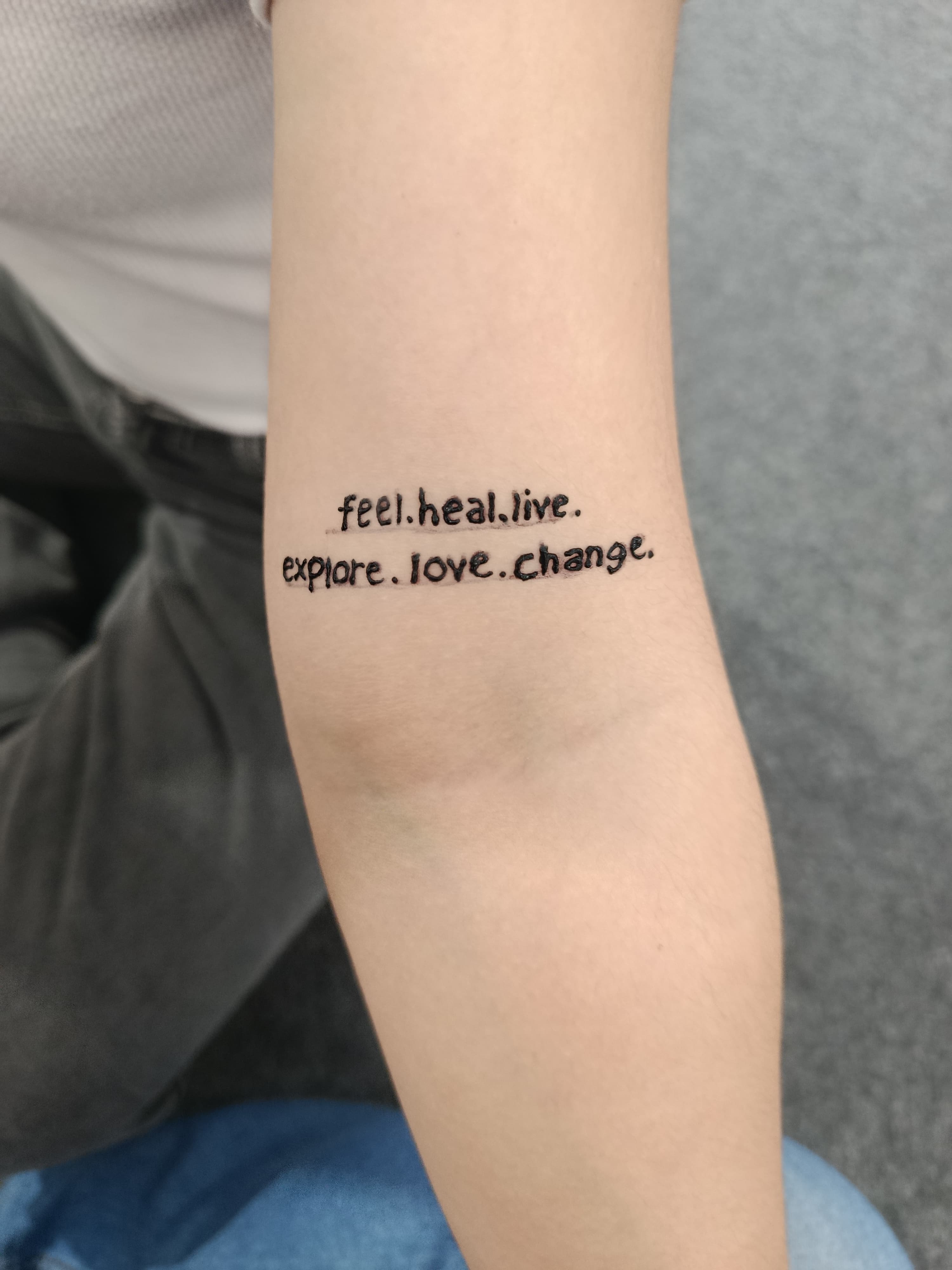 Small black lettering tattoo on an inner arm